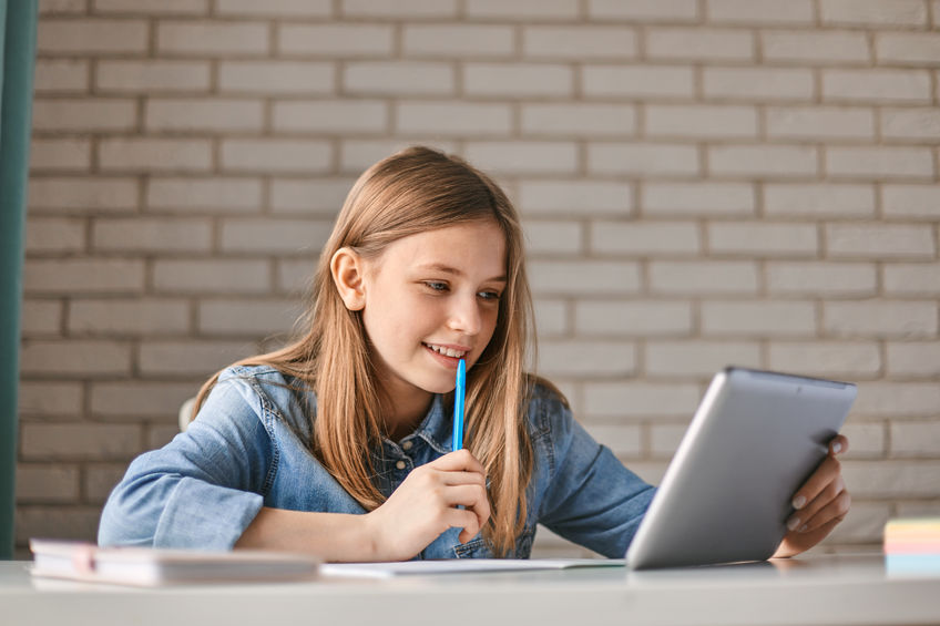 Middle school girl working on a computer in a flexible homeschooling schedule.